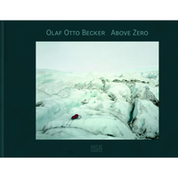The cover of the book Above Zero by Olaf Otto Becker. The main image is a photograph of a vast, desolate glacier landscape under a pale, overcast sky. The icy surface is a mix of white and pale green, with deep, dark crevasses. A small, red sled sits alone on the ice in the foreground, highlighting the immense scale of the environment. The publisher's name, Hatje Cantz, is at the bottom.
