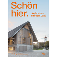 The book cover for Schön hier. Architektur auf dem Land, featuring a modern, barn-like building with a concrete base and a slatted wood facade in a village setting.