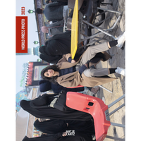 The cover of World Press Photo 2023, featuring a young woman in a tan coat sitting at a table in a crowded public space, looking directly at the camera while other people, including women in chadors, are in the background.