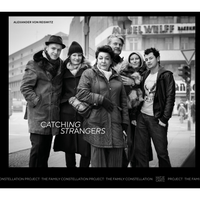 A black and white photograph of a group of six diverse people posing together for a portrait on a city street.