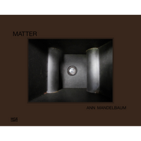 The book cover for Matter by Ann Mandelbaum shows a dark interior space with two large columns and a central, circular peephole.