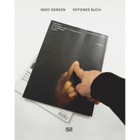 A hand holds the book Offenes Buch by Ingo Gerken, which features a dark cover with a photograph of another hand touching a surface.