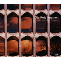 A close-up of a modern building facade with a repeating geometric pattern, where the windows reflect an orange sky and silhouetted trees.
