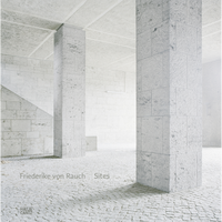 An architectural space with two large, square pillars made of light-colored, textured stone on a cobblestone floor.