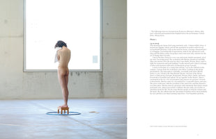 An open book spread. The left page shows a photograph of a nude person with their back to the camera, standing on a small wooden stool inside a blue hoop on a concrete floor. The right page contains a typed diary entry, dated 14.11.2024, about a performance art workshop.