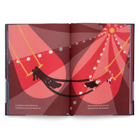 An open book displays a stylized two-page illustration of a trapeze act inside a red circus tent. A large, dark shadow figure with white eyes hangs from a trapeze on the left, its long arms stretching across the center to hold hands with a person in a red costume on a trapeze to the right, as they swing under spotlights.