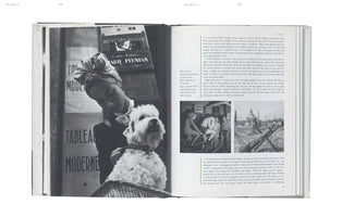 A black-and-white photo of an open book. The left page shows a large photograph of a woman wearing a turban and holding a white terrier dog. The right page contains English text and two smaller photos, one of men on stationary bikes and the other of a Parisian monument behind barbed wire.
