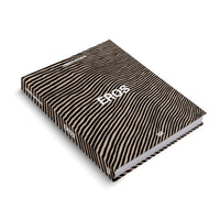 A hardcover book titled EROS by Christl Mudrak, presented at an angle on a white surface. The book's cover features a hypnotic pattern of wavy, parallel black and beige stripes that continue onto the spine. The title is written in white, curving with the lines.
