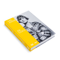 A hardcover book titled Les Années Folles de Coco Chanel, lying at an angle on a white surface. The cover features a black and white photograph of Coco Chanel in a patterned cardigan with her arms crossed. A wide, bright yellow band runs down the spine and part of the front cover, displaying the title in white text.