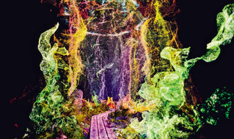 A vibrant digital rendering of a magical cave created from millions of glowing particles in neon green, yellow, and purple against a black background. A wooden walkway leads into the center of the cavern, where a small, lone figure stands, gazing into the ethereal, dreamlike scene.