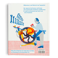 The back cover of a book with a stylized illustration of a printer at work. The man wears a blue apron and stands beside a large printing press rendered in overlapping red, yellow, and blue. Above him, a set of blue wrenches is arranged in an arc. The cover includes German text and a red grid pattern at the bottom.