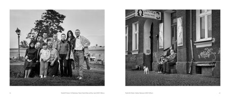 A two-page book spread in black and white. On the left, a large family of nine people poses for a portrait in a grassy park. On the right, a smaller group of four people and a small white dog sit on the steps of a building on a cobblestone street.
