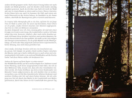 A page from a book with German text on the left and a color photograph on the right. The photo, taken in 1982, shows a young woman, artist Katharina Grosse, sitting cross-legged on the ground in a sunlit forest. Behind her, a large white sheet of paper is stretched between two trees, forming an outdoor art installation.