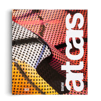 The book cover for BMW Art Cars, published by Hatje Cantz. The cover features a vibrant and abstract close-up of a car's surface, showcasing a mix of colorful patterns including red perforated grids, black halftone dots on white and orange backgrounds, and a black honeycomb texture. The title, art cars, is written vertically in large, bold white text on the right side of the cover.
