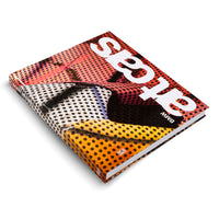 A hardcover book, BMW Art Cars, is shown angled on a white background. The cover features a vibrant, close-up abstract image with a halftone dot pattern in orange, red, white, and black. The title is in large white letters, and the publisher, Hatje Cantz, is on the spine.