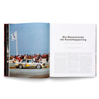 An open book on a white surface, displaying a two-page spread. The left page features a full-page color photograph of the number 50 BMW Art Car, a 3.0 CSL, with a vibrant yellow, white, and black geometric livery, racing on a track. The right page has an article in German with the large headline Die Rennstrecke als Kunsthappening.