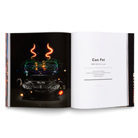 An open book showing a two-page spread. The left page features a photo of a black BMW M6 GT3 against a black background, with vibrant, multi-colored light trails and swirls painted in the air around and above the car. The right page is white with black text, identifying the artist as Cao Fei and the work as BMW M6 GT3, 2016.
