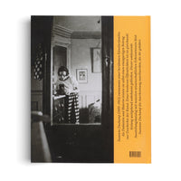 The back cover of a book, split vertically. On the left is a black-and-white photograph of a woman with dark hair in striped pants, standing in a room and looking down at an object on a dresser. On the right is a mustard-yellow panel with German text and a barcode.