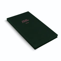 A studio shot of a rectangular, dark green box with a textured, fabric-like finish, set against a white background. On the top lid, the name HILMA af KLINT and the word Flora are printed in a light pink serif font. The box is shown at an angle, casting a gentle shadow.