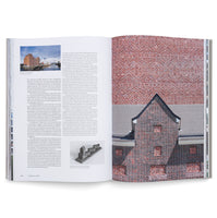 Open book spread displaying a black and white architectural photograph of a modernist building facade with repetitive window patterns on the left page, and German text on the right page.